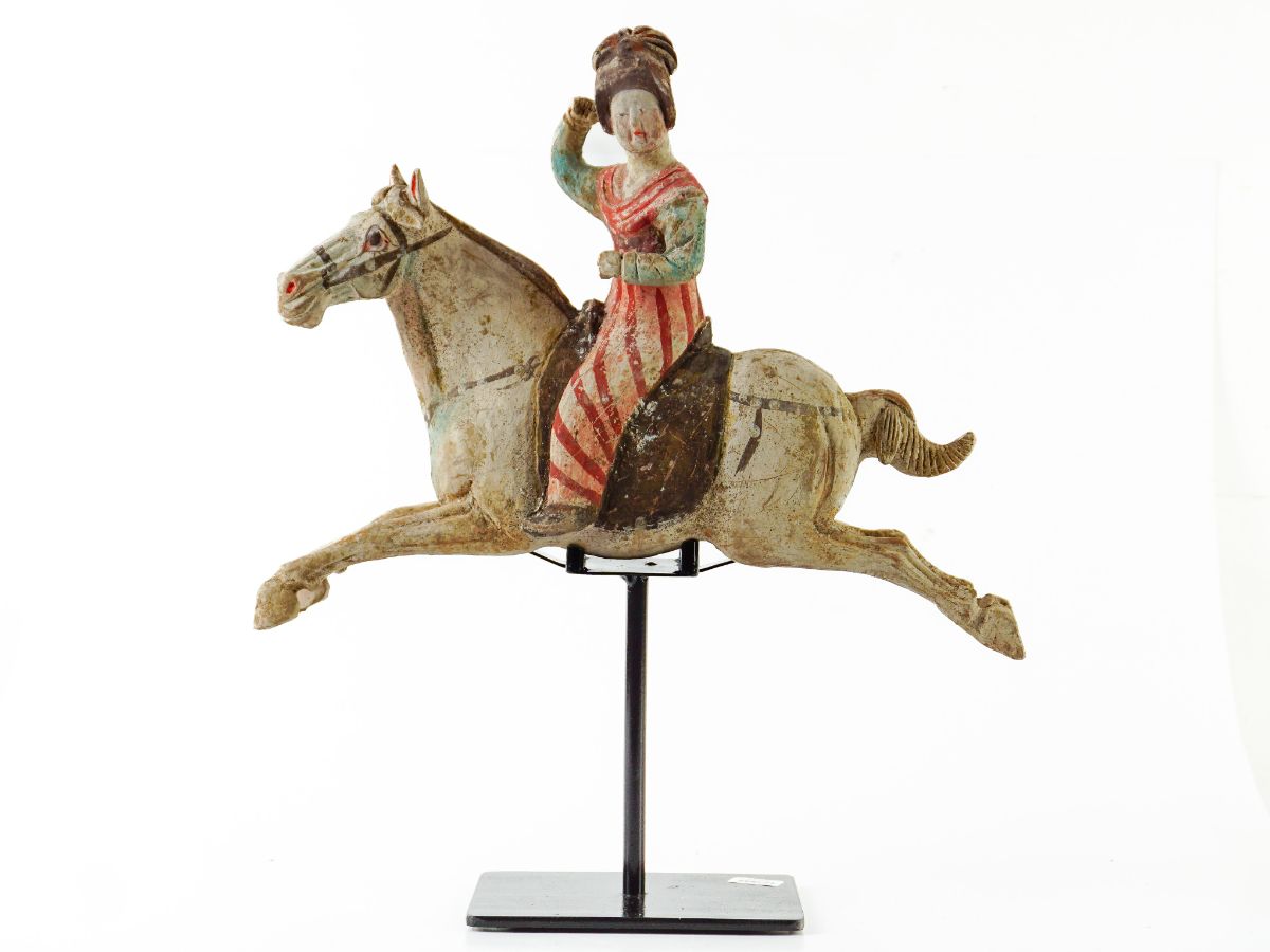 Jogadora astride de polo sobre cavalo a galope